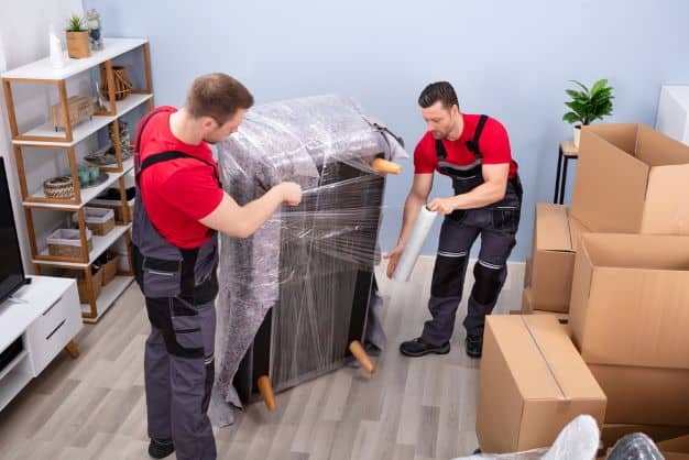 Two men unpacking a sofa